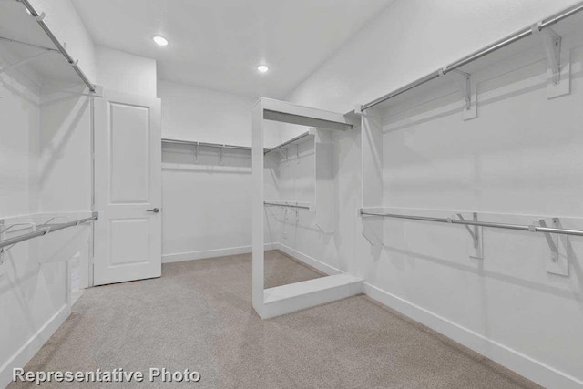 walk in closet with light colored carpet