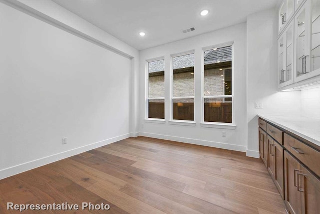 unfurnished dining area with recessed lighting, light wood-style floors, visible vents, and baseboards
