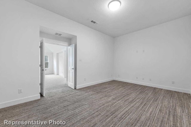 carpeted spare room featuring baseboards and visible vents