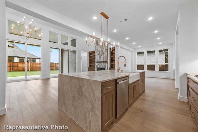 kitchen with open floor plan, dishwasher, a sink, and a chandelier