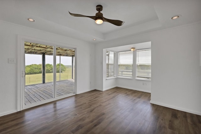spare room featuring a ceiling fan, a tray ceiling, baseboards, dark wood-style floors, and recessed lighting