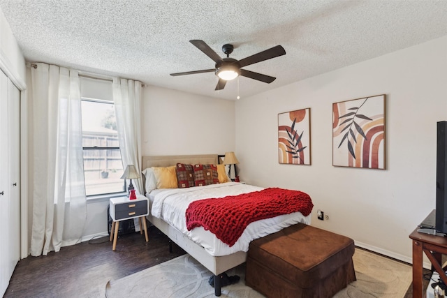 bedroom featuring a ceiling fan, wood finished floors, a textured ceiling, a closet, and baseboards