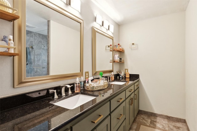 full bathroom featuring double vanity, baseboards, and a sink