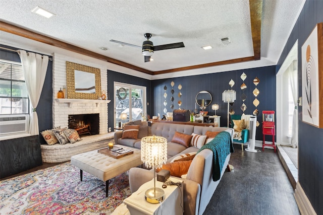 living room featuring wood finished floors, a textured ceiling, a ceiling fan, and visible vents