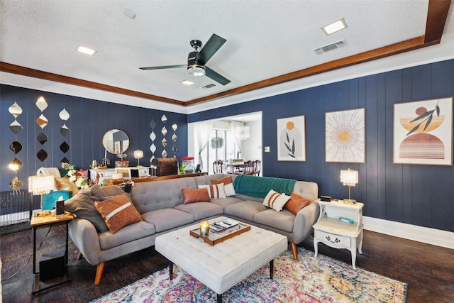 living room with a textured ceiling, ceiling fan, and crown molding