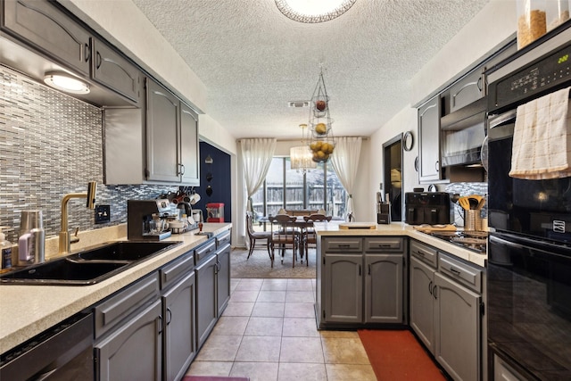 kitchen with black appliances, a peninsula, a sink, and light countertops