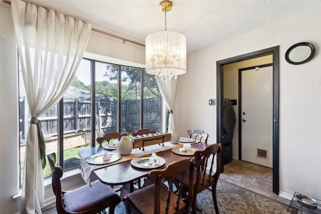 dining space with a chandelier, a textured ceiling, tile patterned floors, and visible vents