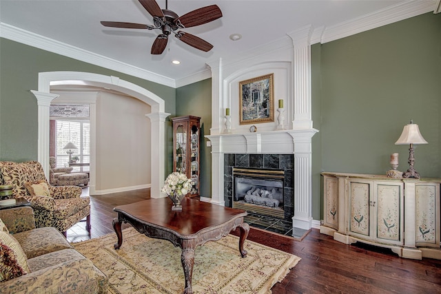 living room featuring recessed lighting, hardwood / wood-style floors, arched walkways, a tiled fireplace, and ceiling fan