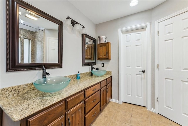full bathroom with tile patterned flooring, a sink, and double vanity