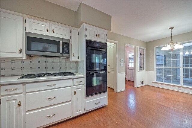 kitchen featuring light countertops, light wood finished floors, appliances with stainless steel finishes, and white cabinets