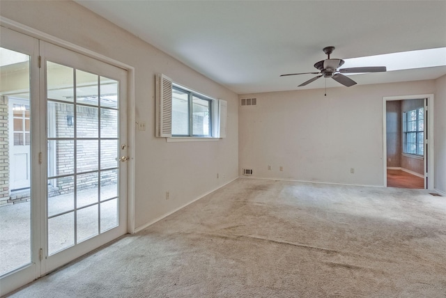 carpeted spare room featuring a ceiling fan, baseboards, and visible vents