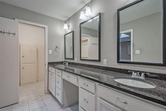 bathroom featuring a sink, double vanity, and marble finish floor
