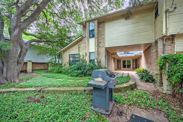 rear view of house with brick siding, a patio area, and fence