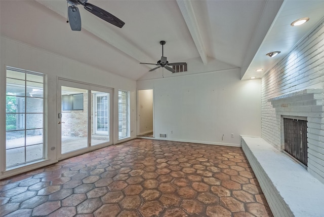 unfurnished living room with a brick fireplace, a ceiling fan, lofted ceiling with beams, and stone finish flooring