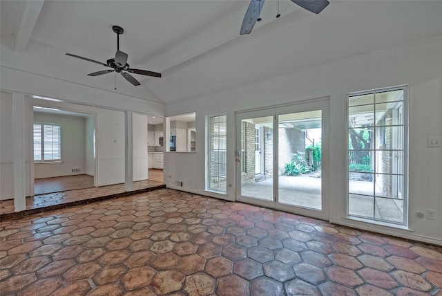 spare room with lofted ceiling with beams, a ceiling fan, and stone finish flooring