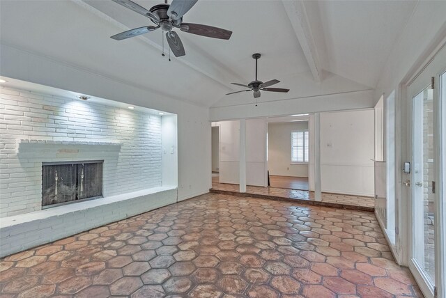 unfurnished living room with a fireplace, baseboards, ceiling fan, vaulted ceiling with beams, and stone finish flooring