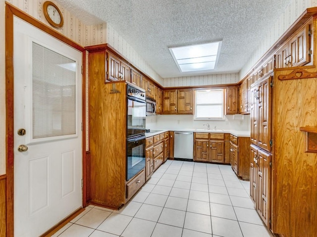 2011 Vicksburg Dr, Sachse, TX 75048 - kitchen featuring light tile patterned floors, brown cabinets, wallpapered walls, black appliances, and light countertops