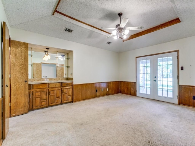 2011 Vicksburg Dr, Sachse, TX 75048 - spare room featuring french doors, a textured ceiling, visible vents, wood walls, and a wainscoted wall