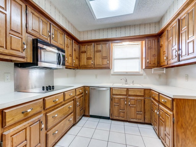 2011 Vicksburg Dr, Sachse, TX 75048 - kitchen featuring brown cabinetry, stainless steel appliances, wallpapered walls, and a sink