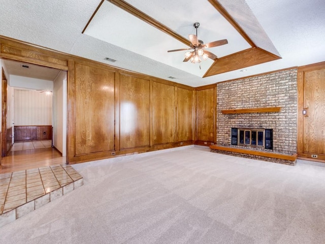 2011 Vicksburg Dr, Sachse, TX 75048 - unfurnished living room featuring wood walls, light colored carpet, visible vents, ceiling fan, and a brick fireplace