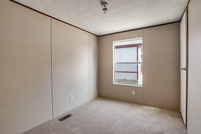 carpeted spare room featuring visible vents