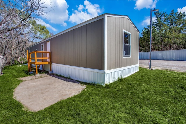 view of home's exterior featuring a patio area, a lawn, and fence