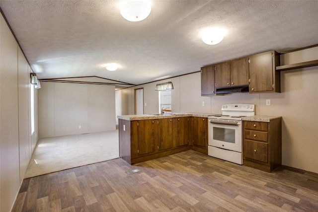 kitchen with white range with electric stovetop, wood finished floors, light countertops, a peninsula, and under cabinet range hood
