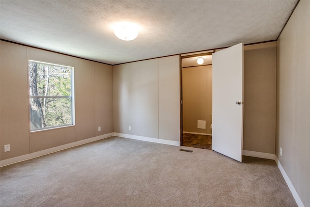 unfurnished bedroom featuring carpet floors, a textured ceiling, visible vents, and baseboards