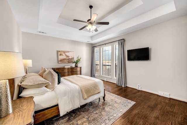 7020 Belcrest Dr, Plano, TX 75024 - bedroom with a tray ceiling, dark wood-style floors, baseboards, and a ceiling fan
