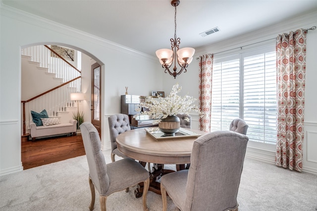 12067 Sunny St, Frisco, TX 75033 - dining space featuring carpet, a chandelier, stairway, arched walkways, and crown molding
