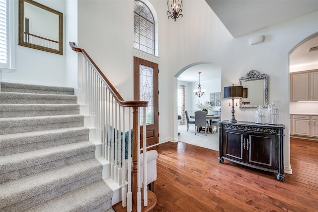 12067 Sunny St, Frisco, TX 75033 - foyer with a chandelier, arched walkways, stairs, hardwood / wood-style floors, and healthy amount of natural light