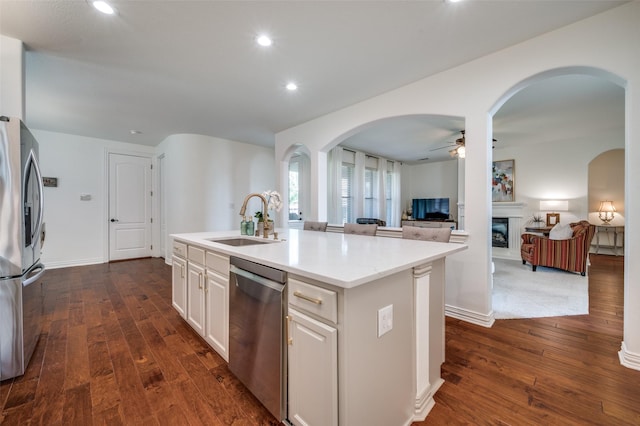 12067 Sunny St, Frisco, TX 75033 - kitchen with a sink, appliances with stainless steel finishes, arched walkways, a fireplace, and a ceiling fan