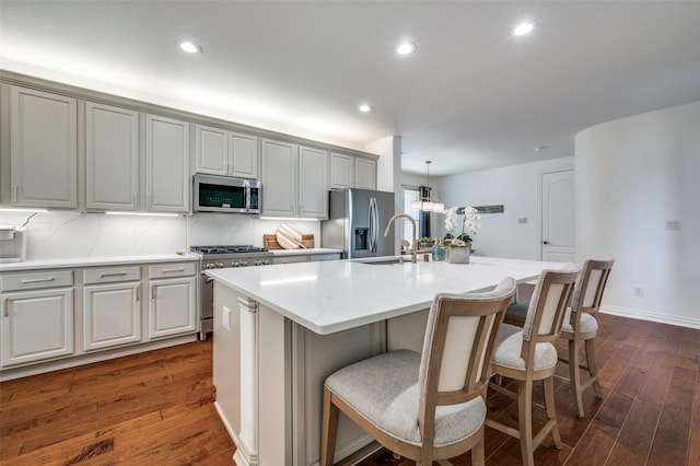 12067 Sunny St, Frisco, TX 75033 - kitchen with stainless steel appliances, dark wood finished floors, a sink, an island with sink, and a kitchen bar