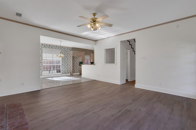 unfurnished living room with baseboards, visible vents, a ceiling fan, wood finished floors, and ornamental molding