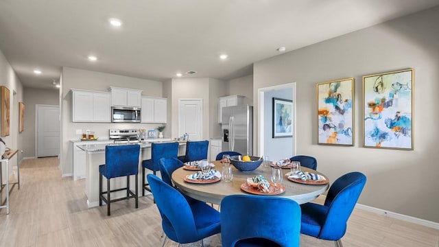 dining space featuring light wood-type flooring, baseboards, and recessed lighting