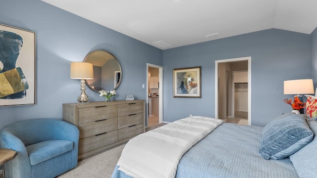 bedroom with a walk in closet, lofted ceiling, visible vents, and light colored carpet