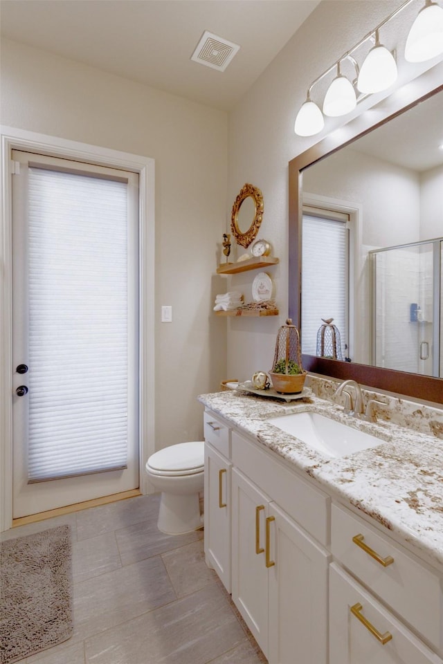full bathroom with tile patterned floors, toilet, a stall shower, visible vents, and vanity