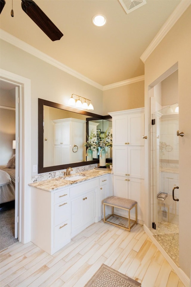 ensuite bathroom with a stall shower, wood finished floors, crown molding, vanity, and connected bathroom