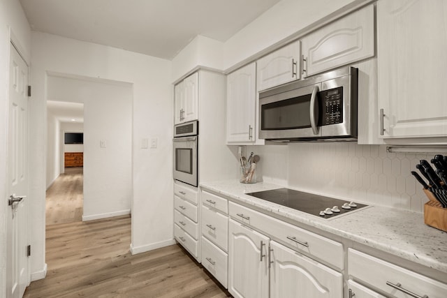 1764 Brown Trl, Hurst, TX 76054 - kitchen with stainless steel appliances, light wood-style floors, tasteful backsplash, and white cabinetry