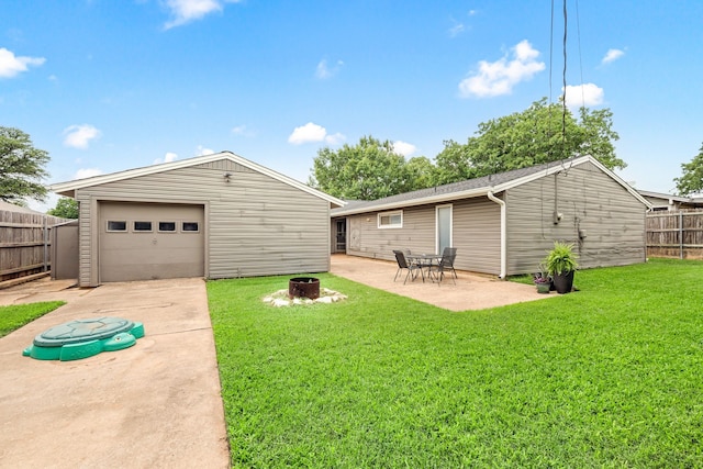 1764 Brown Trl, Hurst, TX 76054 - back of property with a detached garage, an outdoor structure, driveway, a fire pit, and a patio area