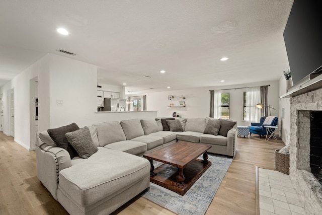 1764 Brown Trl, Hurst, TX 76054 - living room featuring a stone fireplace, recessed lighting, and light wood-style floors
