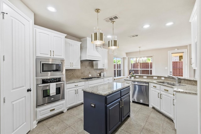 kitchen featuring white cabinets, stainless steel appliances, visible vents, and a sink