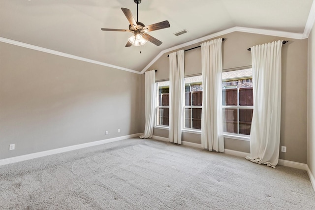 carpeted empty room with a ceiling fan, baseboards, lofted ceiling, ornamental molding, and visible vents