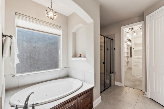 bathroom with a shower stall, a tub with jets, and tile patterned floors