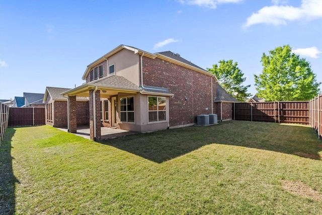back of property with a lawn, a patio area, a fenced backyard, and brick siding