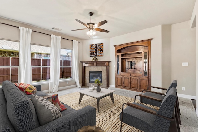 living area with carpet floors, baseboards, visible vents, a ceiling fan, and a fireplace