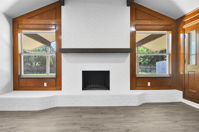 6709 Santiago Ave, Fort Worth, TX 76133 - unfurnished living room featuring vaulted ceiling, healthy amount of natural light, wood finished floors, and a brick fireplace