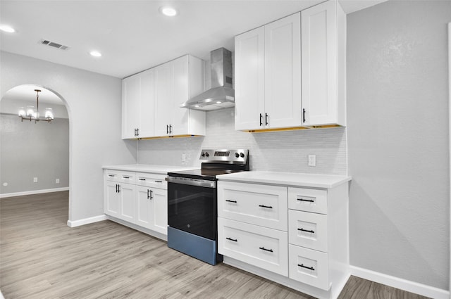 6709 Santiago Ave, Fort Worth, TX 76133 - kitchen with electric stove, wall chimney exhaust hood, arched walkways, tasteful backsplash, and light countertops