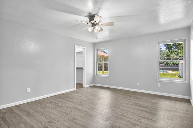 6709 Santiago Ave, Fort Worth, TX 76133 - unfurnished room with plenty of natural light, a ceiling fan, wood finished floors, and baseboards