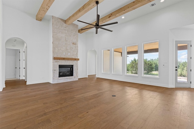 7103 Heathington Ct, Granbury, TX 76049 - unfurnished living room with ceiling fan, a towering ceiling, wood-type flooring, and arched walkways